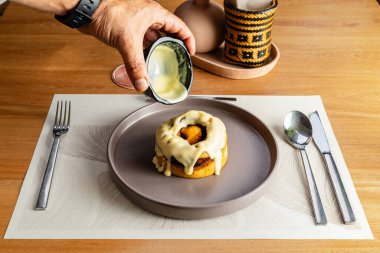 Süngerimsi ve tatlı beyaz soslu nefis tarçınlı rulo. Zarif otel restoranı, gastronomi ve tatlılar..