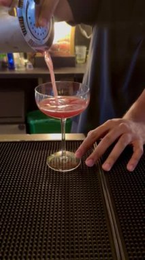 Barmen, Kolombiya 'daki lüks bir barda kokteyl karıştırıcısından rom ile yapılan zarif, koyu kırmızı bir kokteyl servisi yapıyor..