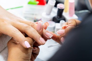 Mujer Latin Kolombiyalı en spa de uas. Manicurista haciendo limpieza y decacin de uas. Belleza y moda.