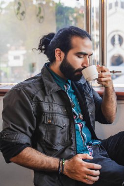 Latin sakallı adam, restoranda Kolombiya kahvesi içiyor. Soğuk hava. Nefis kahve..