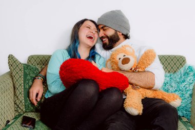 Latin evli çift Sevgililer Günü 'nde çok mutlu bir şekilde paylaşıyorlar. Oyuncaklar, detaylar ve kocaman bir kalp. İfadeler ve flörtler. Boşluğu kopyala.