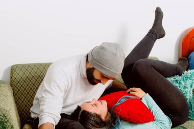 Sevgililer Günü, aşk ve arkadaşlık. Latin evli çift mutlu ve birbirlerine bakarken kanepede birbirlerine sarılıyorlar. Boşluğu kopyala.