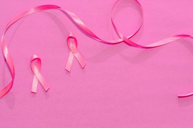 Dünya Kanser Günü. Pembe kurdeleler göğüs kanserini temsil ediyor. Pembe arka planda kopyalamak için yer var. Kişisel bakım ve önleme. Kuvvet.