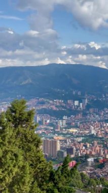 Medellin Kolombiya şehrinin günbatımında, dağdaki bakış açısından çekilmiş dikey bir video. Medellin Komünleri.