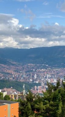 Medellin Kolombiya şehrinin günbatımında, dağdaki bakış açısından çekilmiş dikey bir video. Medellin Komünleri.