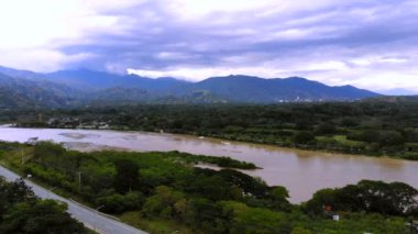 Santa Fe de Antioquia 'dan Cauca nehrinin görüntüsü otoyolu ve sarı asma köprüyü gösteriyor..