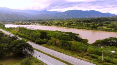Santa Fe de Antioquia 'dan Cauca nehrinin görüntüsü otoyolu ve sarı asma köprüyü gösteriyor..