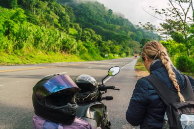 Latin bir gezgin ormanın ortasında haritasına bir yol ile bakıyor. Parlak ve soğuk renkler. Seyahat ve Kolombiya.