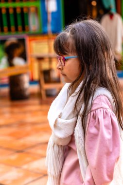  Atkısı ve ceketi olan güzel Latin kız Kolombiya 'da tatilinin tadını çıkarıyor. Geziler, geziler, gülümseyen insanlar. Çocuk Günü.