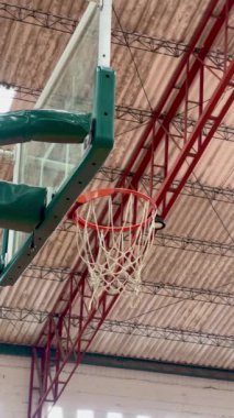 Basketbol toplarının kapalı alanda basketbol potalarına yakın çekim atışları.