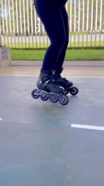 Güzel, genç, Kolombiyalı Latin bir kadının spor yaptığı, sahada kaymayı öğrendiği ve eğlendiği dikey bir video..