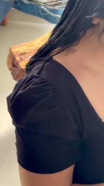 Latin bir kadın arkadaşının uzun mavi saçlarını ev yapımı saç boyası ve plastik eldivenleriyle koyu kahverengiye boyuyor..