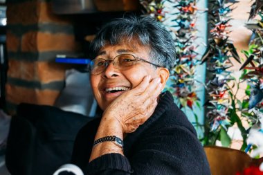 Afro Kolombiyalı Latin, son sınıf öğrencisi, yetişkin bir kadın doğum günü hediyesi için gülümsüyor.