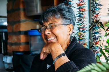 Afro Kolombiyalı Latin, son sınıf öğrencisi, yetişkin bir kadın doğum günü hediyesi için gülümsüyor.