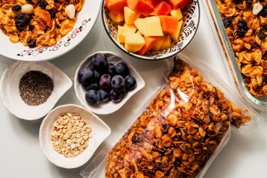 El yapımı granola, meyve mangosu, papaya ve üzümlü sağlıklı kahvaltı malzemeleri.