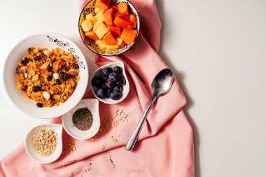 El yapımı granola, meyve mangosu, papaya ve üzümlü sağlıklı kahvaltı malzemeleri.