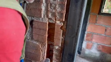 Yaşlı Kolombiyalı adamın evindeki yenileme projesinde elektrik tesisatı için duvarlara delik açarken çekilmiş yatay bir video.