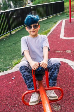 Kolombiyalı bir Latin mestizo 'nun fotoğrafı yukarı aşağı mavi saçlarıyla kameraya bakıp gülümsüyor..