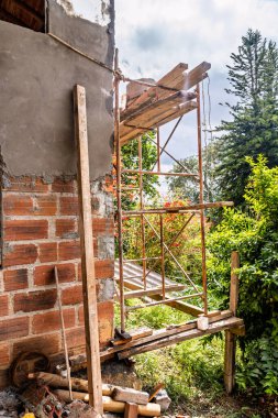 Medellin, Kolombiya yakınlarındaki dağlarda büyük bir evin ön duvarlarını kaplamak için inşaat iskelesinin dikey fotoğrafı..