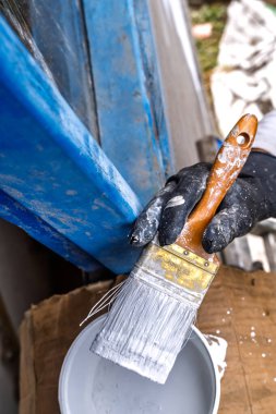 Kolombiya, Medellin yakınlarındaki dağların duvarlarını yeniden şekillendirmek için beyaz boyayla doldurulmuş plastik eldivenli fırça resmi.