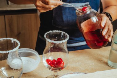 Tanınmayan son sınıf Latin barmen ve barmenin kahve dükkanında maraska kirazlı şekerli moktail ve köpüklü su hazırlarken çekilmiş fotoğrafı.
