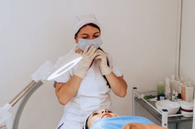 Güzellik merkezindeki iki genç Kolombiyalı kadının fotoğrafı. Dermatolog müşterisine yüz temizleme ameliyatında ne yapacağını anlatıyor..