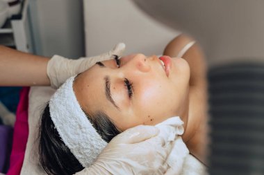 Güzellik merkezindeki genç bir mestiza Kolombiyalı kadının yüz temizleme fırçasının fotokopisi çekilmiş..