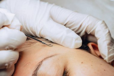 Cilt bakımı kliniğinde sivilceleri ve siyah noktaları temizleyen Kolombiyalı Latin kızın yüz temizleme kliniğinde yakın plan fotoğrafı, cilt bakımı konsepti.
