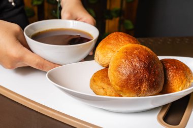 Kolombiya 'da sağlıklı bir vejetaryen restoranında bir kadının elinde geleneksel el yapımı mogolla ekmeğinin yatay fotoğrafı..