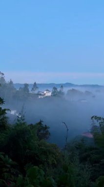 Marinilla, Antioquia, Kolombiya 'daki sisli dağ manzarası, güneş doğmadan önce soğuk kırsal atmosfer, sis Medelln yakınlarındaki tepelerden sürükleniyor şafak öncesi ışık altında
