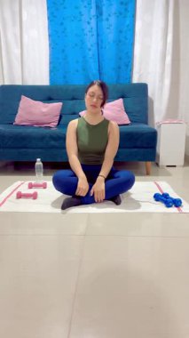 Nilüfer çiçeğinde meditasyon yapan kadının evdeki gerginliği atmak için boynuna dokunduğu dikey bir video.