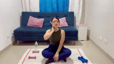 Nilüfer çiçeğinin içinde meditasyon yapan kadın, rahatlamak için boynuna hafifçe dokunur ve kamera ona doğru yaklaşır.