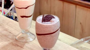 Kolombiya kahve dükkanının arka planında siyah kurabiye milkshake ve çikolatalı milkshake videosu var.