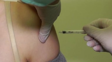 Kadın bir doktor, kadın bir hastaya iğne yapar. Kapat - kapat.