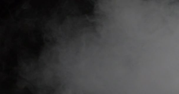 Brouillard blanc ou fumée sur fond d'espace de copie sombre au ralenti. Nuage de brouillard froid dans un endroit lumineux, nuage de fumée de glace. Concept vidéo réaliste animé