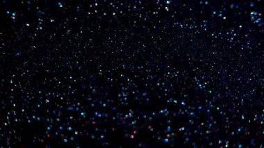 Yavaş çekimde ışıldayan bir patlama Bokeh arka planında parlayan sönmüş ışıltılı toz makrosuyla yakın çekim. Yüzen altın parıltılar. Parlayan Parçacıklar. Üst üste