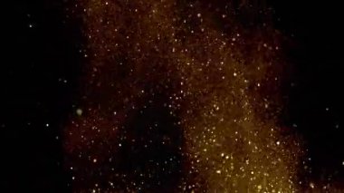 Yavaş çekimde ışıldayan bir patlama Bokeh arka planında parlayan sönmüş ışıltılı toz makrosuyla yakın çekim. Yüzen altın parıltılar. Parlayan Parçacıklar. Üst üste