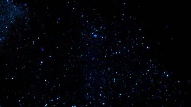 Yavaş çekimde ışıldayan bir patlama Bokeh arka planında parlayan sönmüş ışıltılı toz makrosuyla yakın çekim. Yüzen altın parıltılar. Parlayan Parçacıklar. Üst üste