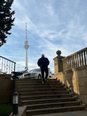A man running up the stairs in front of the TV Tower.
