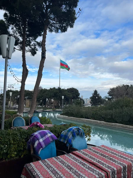 park with pool and azerbaijan flag waving in cloudy weather