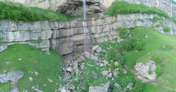 Uma Cachoeira Flui Através Das Montanhas Cercada Por Vegetação — Vídeo de Stock
