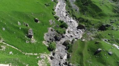 Ortasında kayalar olan yeşil çimlerin havadan görünüşü