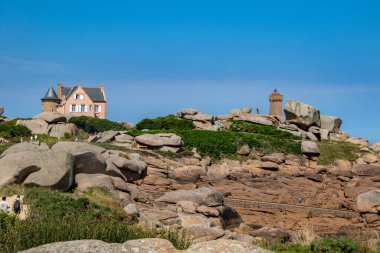 Brittany 'deki pembe granit sahil, mavi denizdeki muhteşem kayalar arasındaki manzara.