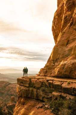 Genç çift Sedona 'daki Katedral Kayası' nın tepesinde dikey poz veriyor..