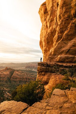 Adam Katedral Rock 'tan dramatik gün batımı manzarasına bakıyor..