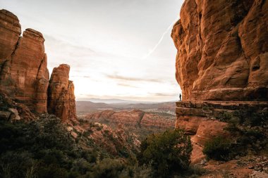 Katedral Rock 'ın bakış açısından Sedona Arizona' da gün batımını izleyen adamın geniş açılı görüntüsü.