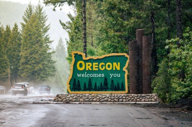 Oregon eyalet sınırına hoş geldiniz diyor. US-HWY 199 Redwood Karayolu Yağmurda.