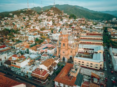 Puerto Vallarta, Jalisco, Meksika 'daki Guadalupe Kilisesi' nin hanımefendisi gün batımında şehir manzarası seyrediyor..