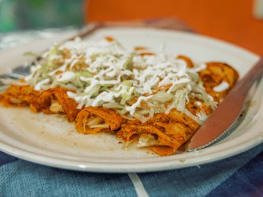 Puerto Vallarta Meksika 'da servis edilen geleneksel kırmızı enchilada tabakta servis edilir..