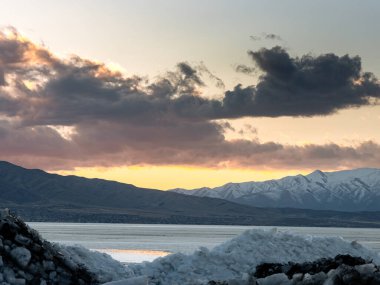 Ice stacks and snowy mountains in Utah at sunset. clipart